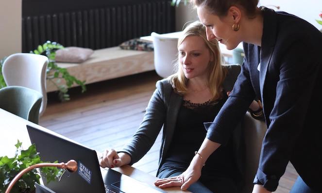 2 female coworkers looking at a laptop